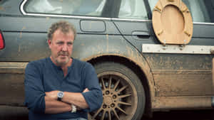 A Man Is Standing Next To A Muddy Car Wallpaper