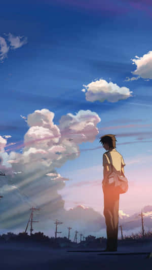 A Man Is Standing On A Road With Clouds In The Background Wallpaper