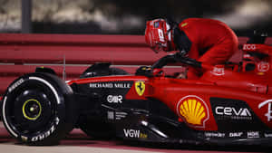 A Man Is Working On The Rim Of A Ferrari Racing Car Wallpaper