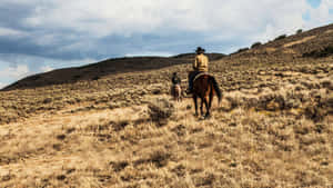 A Man Riding A Horse On A Hill Wallpaper