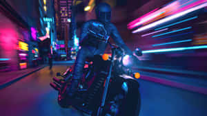 A Man Riding A Motorcycle In A City Wallpaper