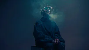 A Man Sitting On A Box With Smoke Coming Out Of His Mouth Wallpaper