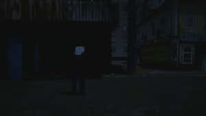 A Man Standing In A Dark Street Wallpaper