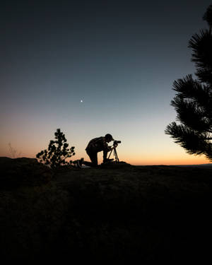 A Man Standing In Silhouette In A Field. Wallpaper