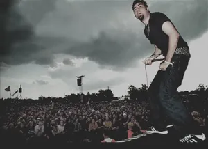 A Man Standing On Stage With A Microphone Wallpaper