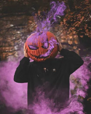 A Man With A Purple Pumpkin Mask And Smoke Wallpaper