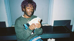 A Man With Purple Hair Holding Money Wallpaper