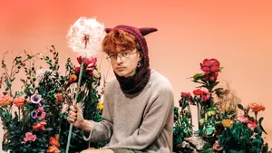 A Man With Red Hair Sitting On A Flower Bed Wallpaper