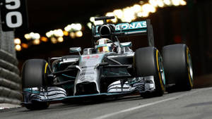 A Mercedes F1 Car Driving Down A Track Wallpaper