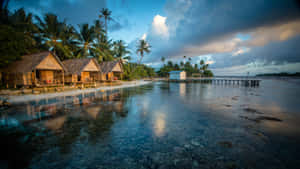 A Mesmerizing Sunset Over A Serene Lake With A Wooden Pier And Lush Vegetation Wallpaper