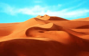 A Mesmerizing View Of Sun-kissed Sand Dunes Under A Stunning Blue Sky. Wallpaper