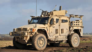 A Military Vehicle Is Driving Down A Dirt Road Wallpaper