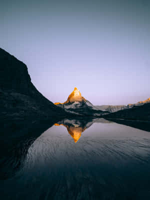 A Mountain Is Reflected In The Water Wallpaper