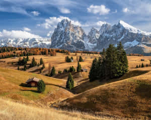 A Mountain Landscape With A House And Trees Wallpaper