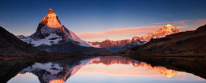 A Mountain Range Is Reflected In A Lake Wallpaper