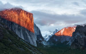 A Mountain Range With A Red Light Shining On It Wallpaper