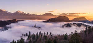 A Mountain Range With Clouds Above It Wallpaper