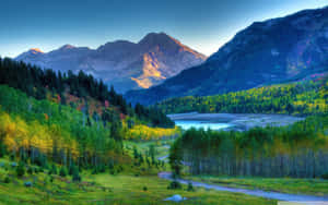 A Mountain Road With Trees And Mountains In The Background Wallpaper