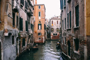 A Narrow Canal With Boats In It Wallpaper