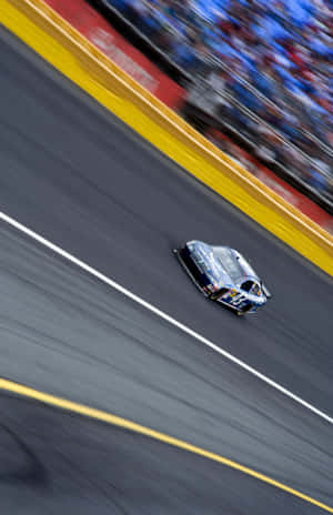 A Nascar Car Is Driving On A Track Wallpaper