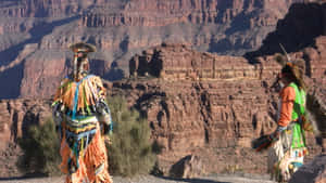 “a Native American Indian Wearing Traditional Dress And Headgear Stands In The Wild.” Wallpaper