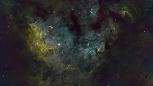 A Nebula With Stars And Green And Yellow Wallpaper