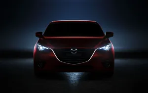 A Neon Red Mazda 2 Illuminated In Nightfall Wallpaper