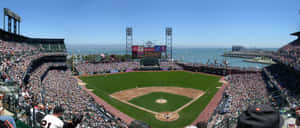 A Packed Baseball Stadium Under The Night Sky Wallpaper