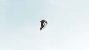 A Pair Of Sneakers Flying Through The Air Wallpaper