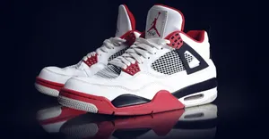 A Pair Of White And Red Air Jordan 4 Sneakers Wallpaper