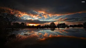 A Peaceful And Serene Reflection Of A Dark Sunset Wallpaper
