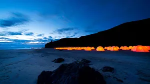 A Peaceful Beach Camping Experience At Sunset Wallpaper