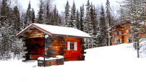 A Peaceful Snowy Retreat At A Cozy Winter Cabin Nestled In The Forest Wallpaper