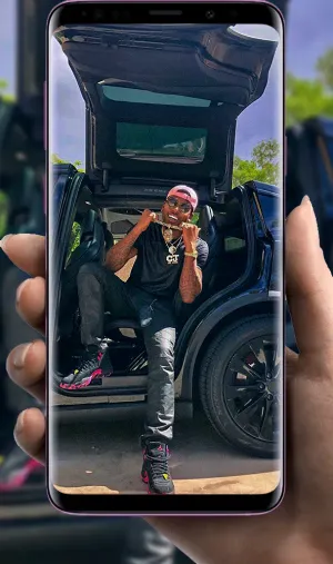 A Person Holding A Phone With A Picture Of A Car Wallpaper