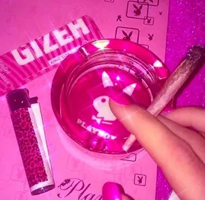 A Person Holding A Pink Ashtray And A Pink Cigarette Wallpaper
