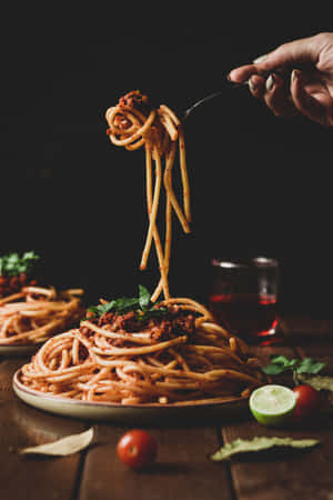 A Person Is Holding Spaghetti On A Plate Wallpaper