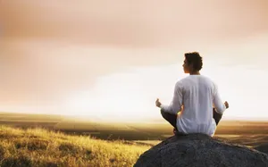 A Person Meditating In A Peaceful Forest At Sunrise Wallpaper