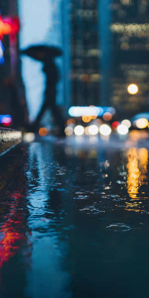 A Person Walking In The Rain Wallpaper