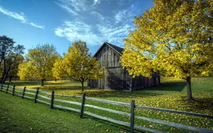 A Picturesque Barn Nestled Amidst The Vibrant Fall Foliage Wallpaper