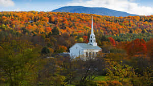 A Picturesque Fall Town Surrounded By Vibrant Autumn Colors. Wallpaper