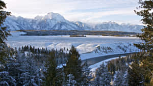 A Picturesque Landscape Of A Wintery Landscape With Snow-covered Mountains Wallpaper