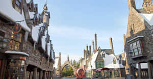 A Picturesque View Of Hogsmeade Village With Snow-capped Rooftops And Warm Glowing Windows Wallpaper