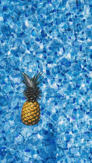 A Pineapple Floating In A Pool Wallpaper