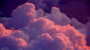 A Pink And Purple Sky With Clouds Wallpaper