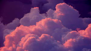 A Pink And Purple Sky With Clouds Wallpaper