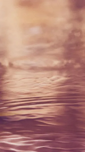 A Pink And Purple Water With Clouds Wallpaper