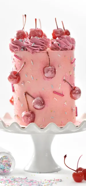 A Pink Cake With Cherries On Top Wallpaper