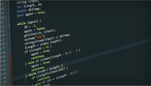 A Programmer Coding On A Computer Desktop. Wallpaper