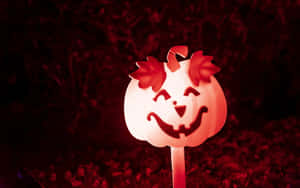 A Pumpkin Is Lit Up In The Dark Wallpaper