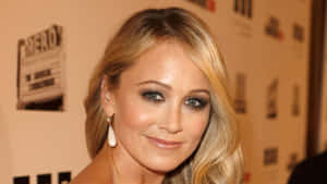 A Radiant Christine Taylor In A Stunning Blue Dress Wallpaper